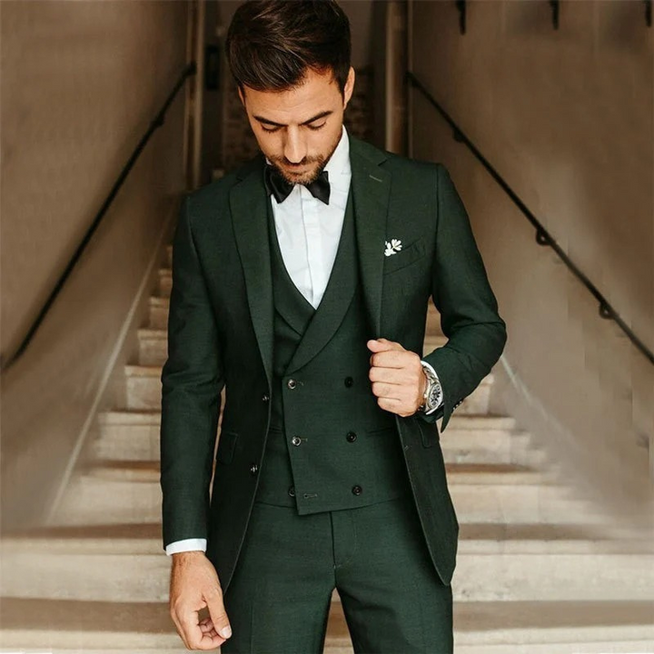 Ein Mann trägt einen klassischen dreiteiligen Anzug mit Blazer, Weste und Hose in einer formellen Umgebung.