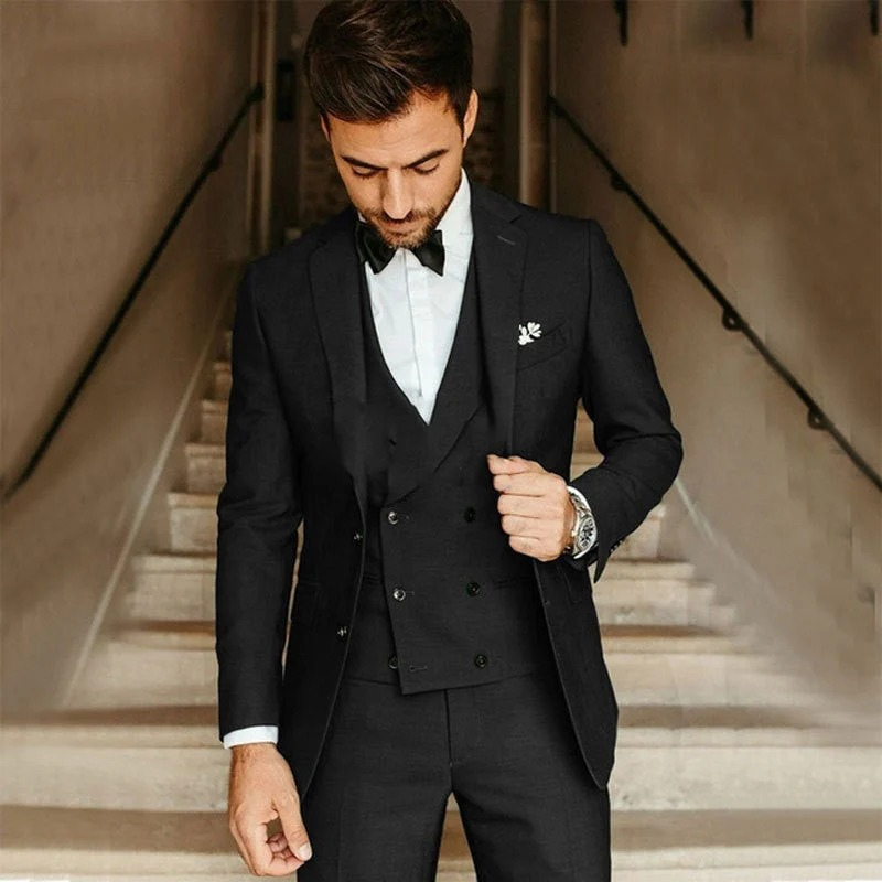 Ein Mann trägt einen klassischen dreiteiligen Anzug mit Blazer, Weste und Hose in einer formellen Umgebung.