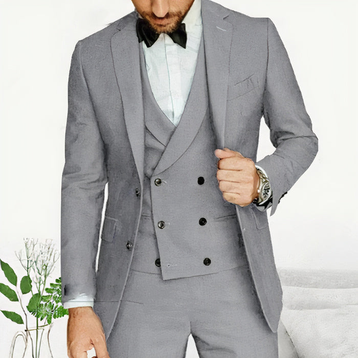 Ein Mann trägt einen klassischen dreiteiligen Anzug mit Blazer, Weste und Hose in einer formellen Umgebung.